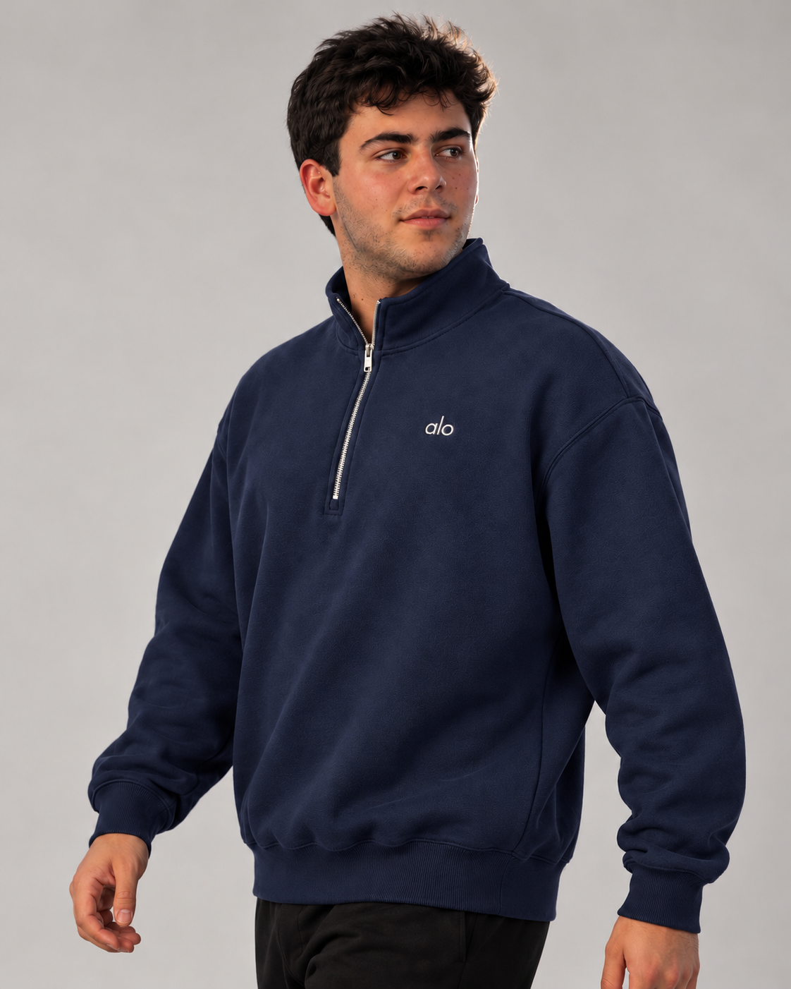 Modelo caminando con sudadera ALO Accolade 1/4 Zip azul marino, vista de tres cuartos